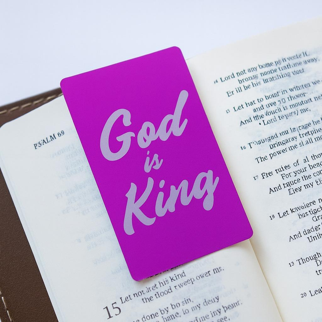 Purple metal bookmark with 'God is King' text on an open bible