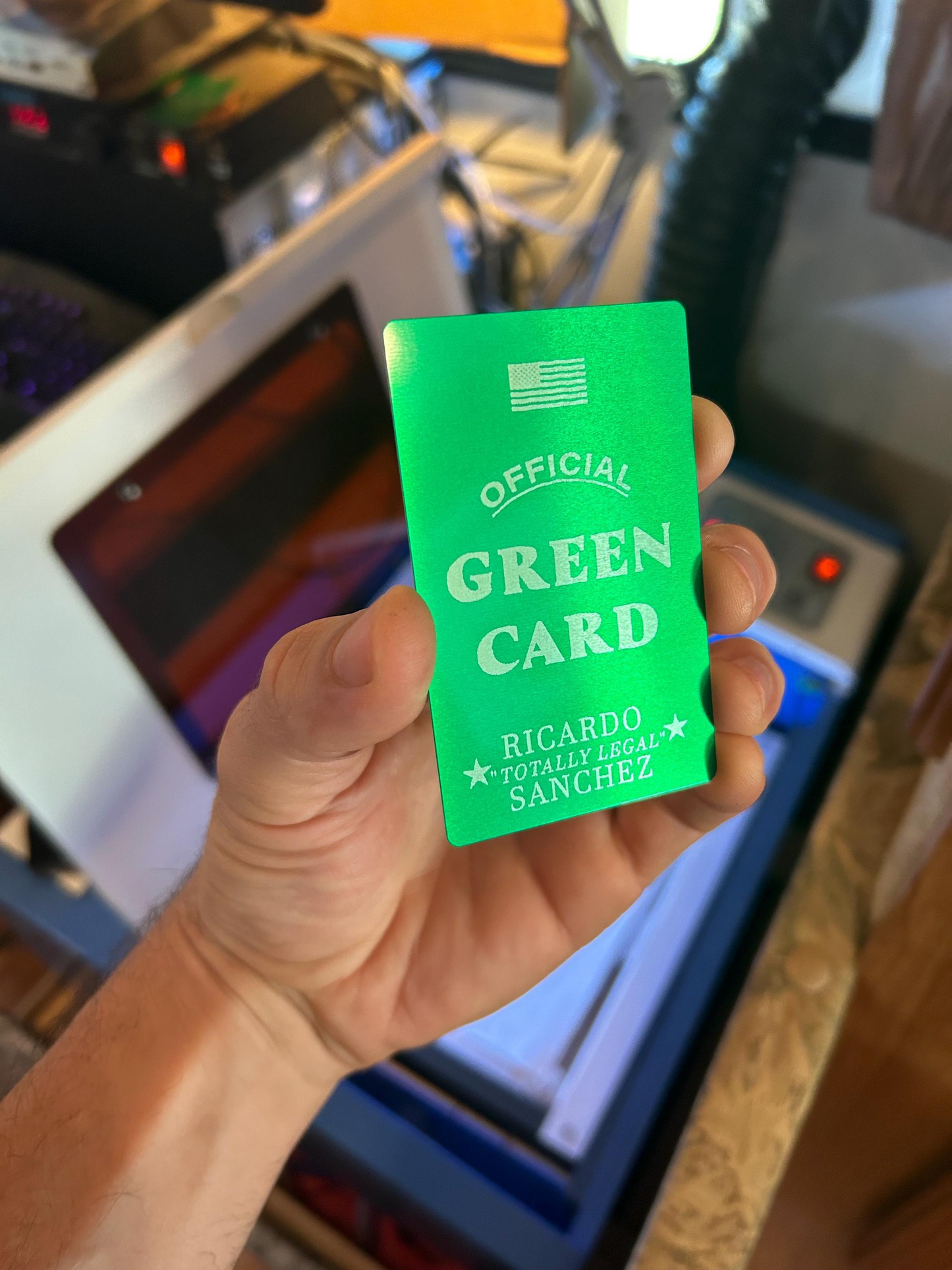 Hand holding metal official green novelty sarcastic gift card, with "Ricardo TOTALLY LEGAL Sanchez" engraved