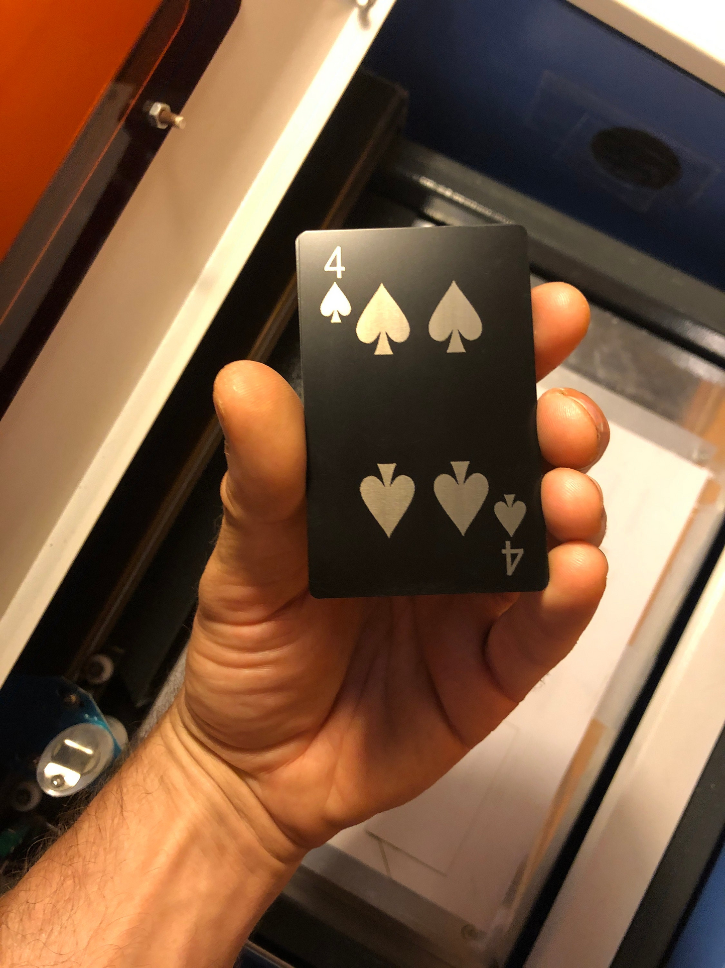 Hand holding a four of spades laser engraved poker gaming gift card