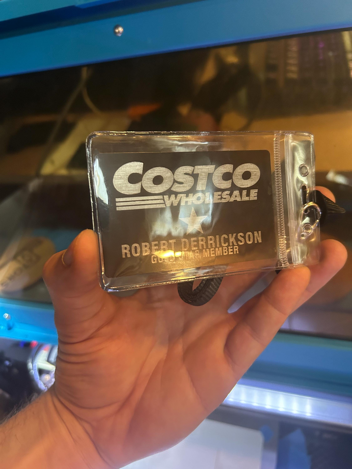 Hand holding a membership card in plastic sleeve lanyard