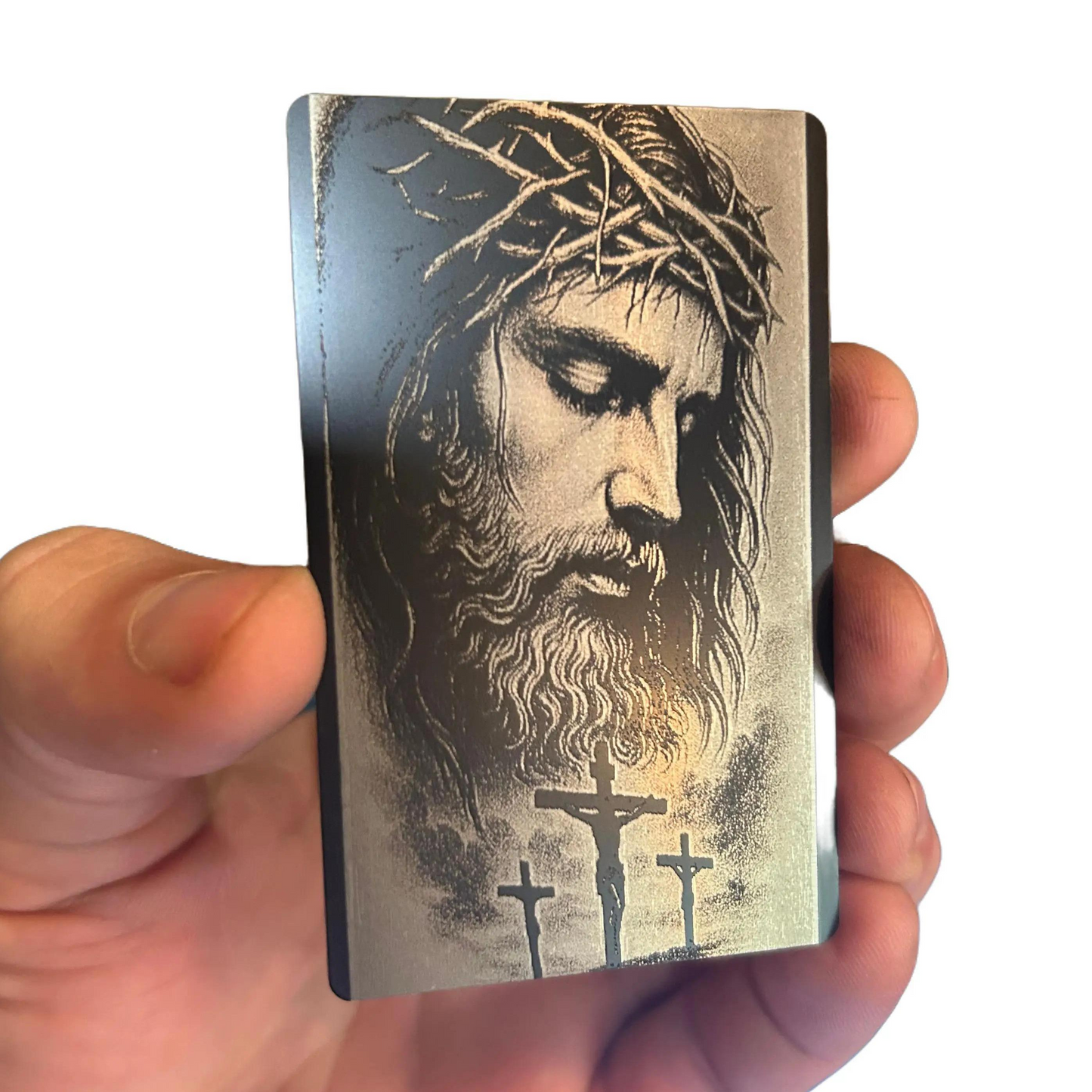 Card with a religious design of a bearded man and crosses held by a hand.