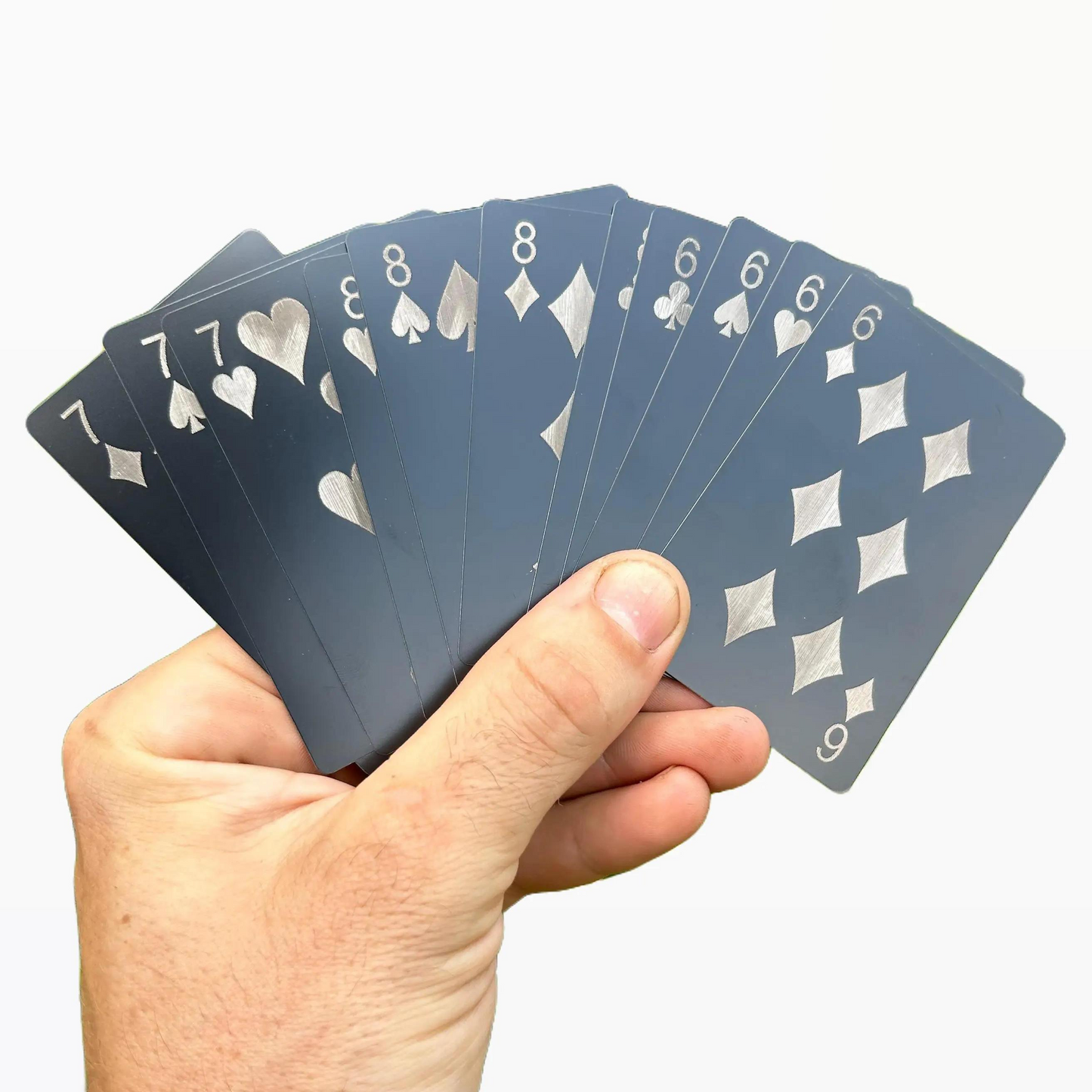 Hand holding a set of metal playing gift cards against a white background