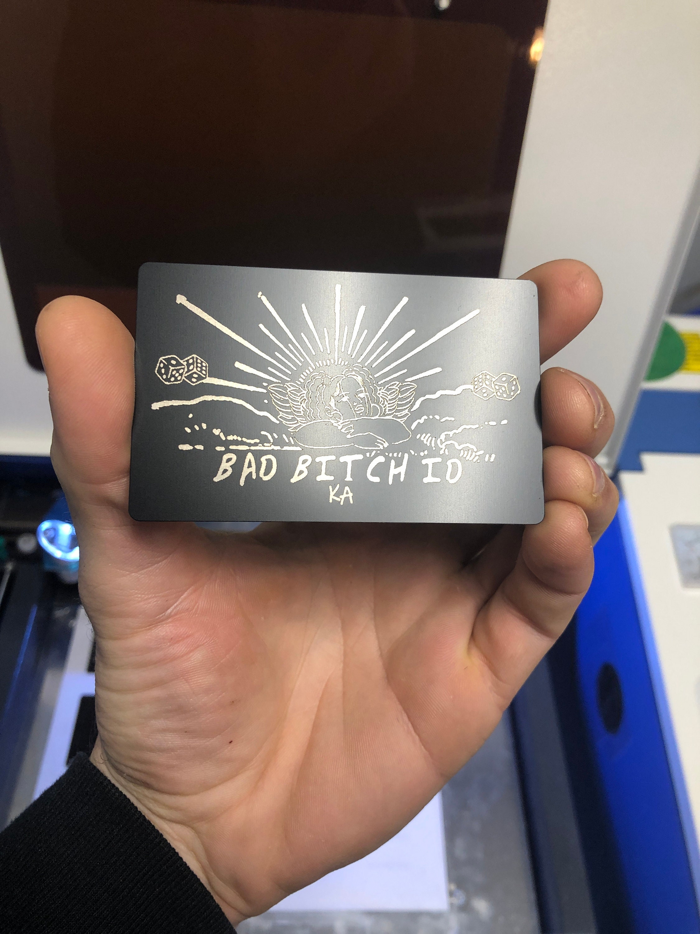 Hand holding a metallic card with text and design