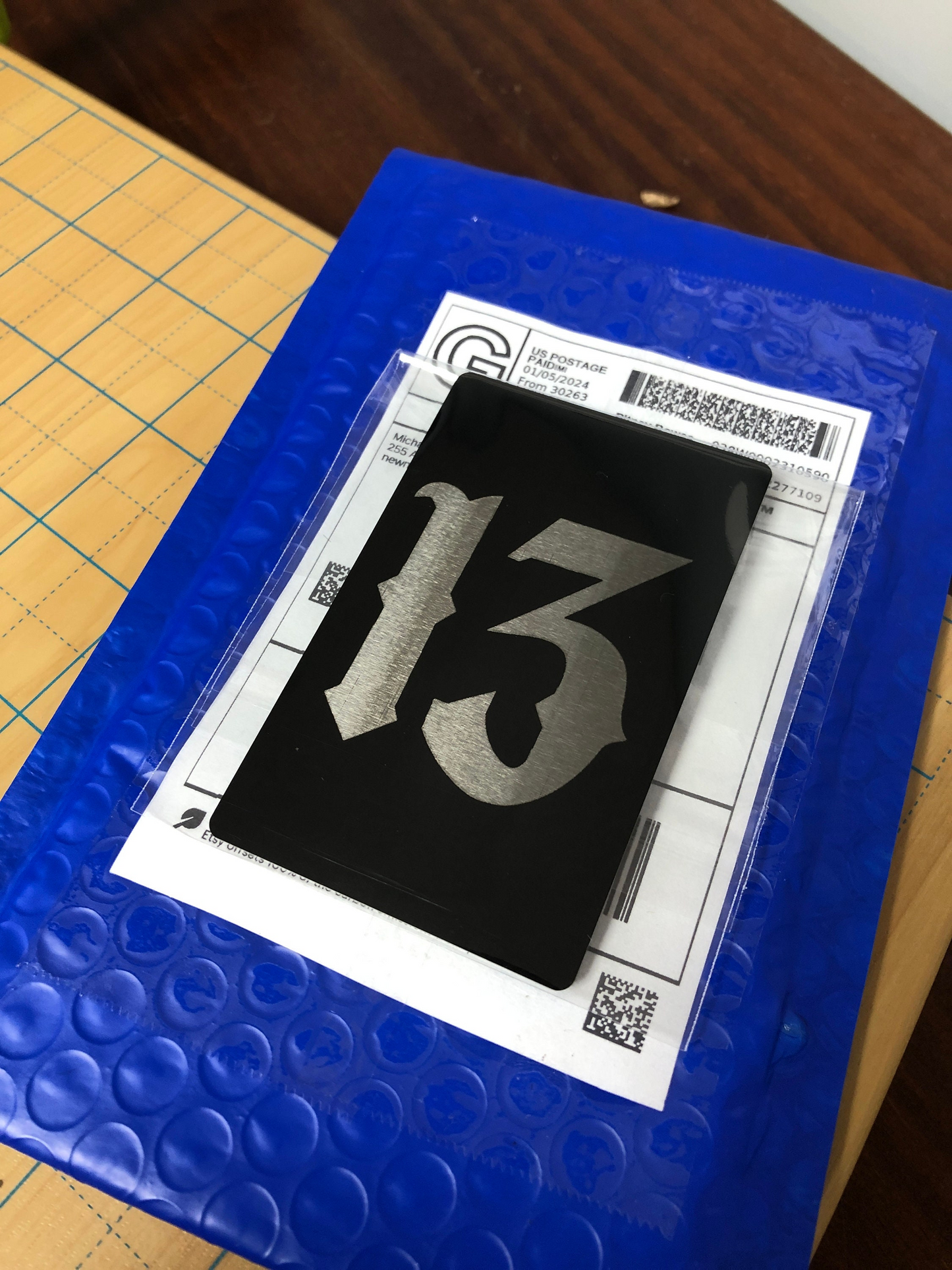 Number 13 laser engraved gothic keepsake gift card on a blue bubble wrap with a clear plastic sheet