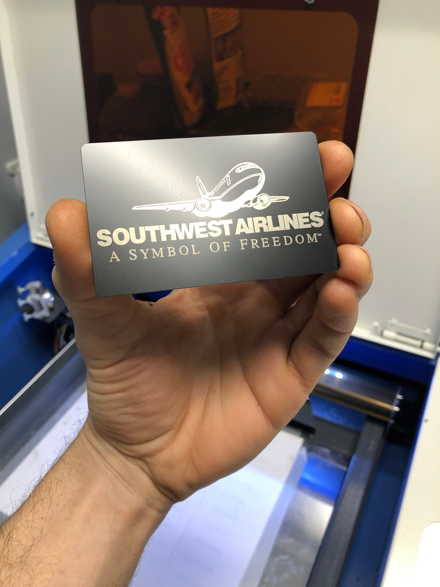 Hand holding a personalized Airlines business card with an airplane logo.