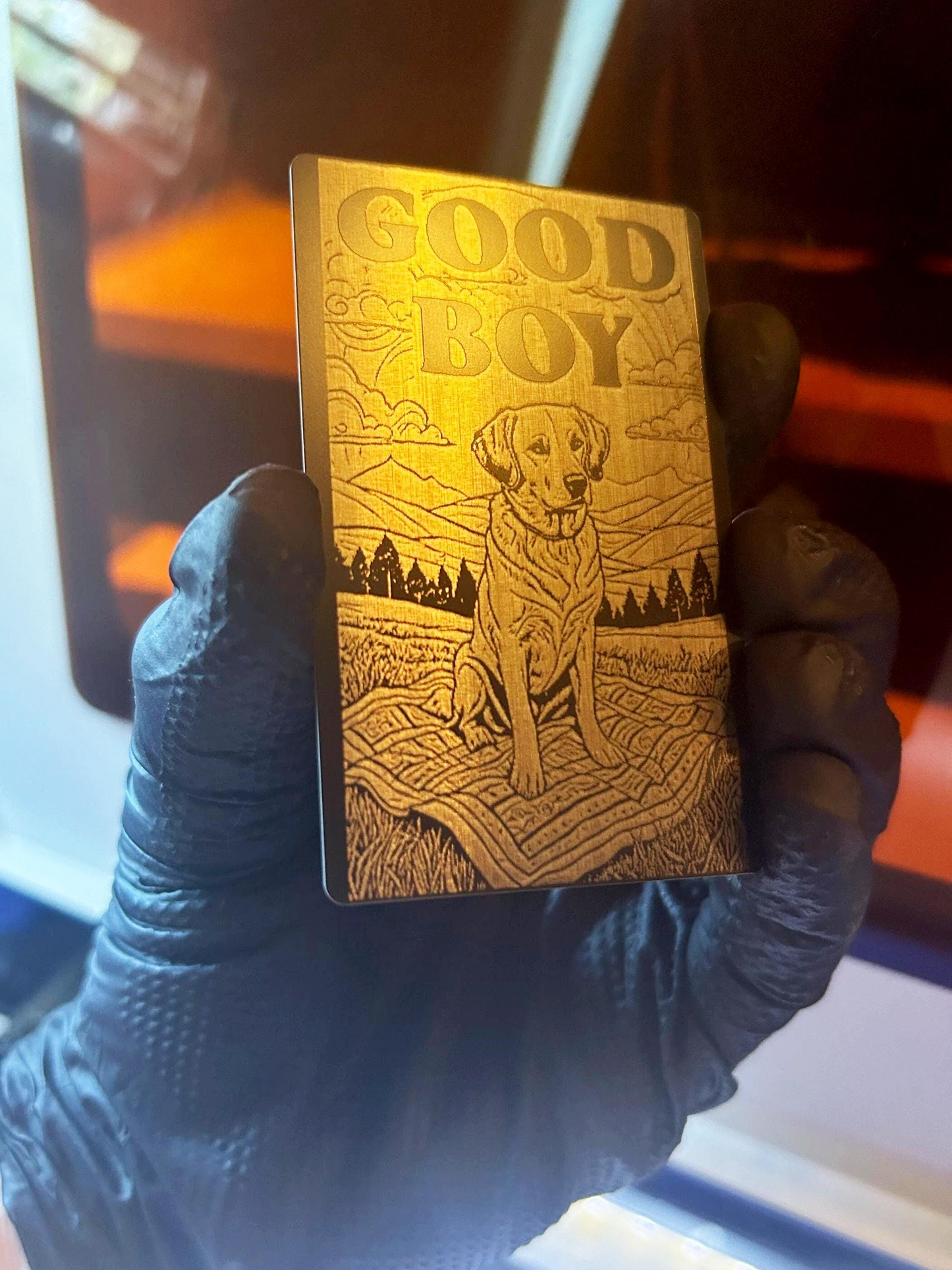 Hand holding a novelty engraved metal card – golden retriever artwork with “Good Boy” typography text