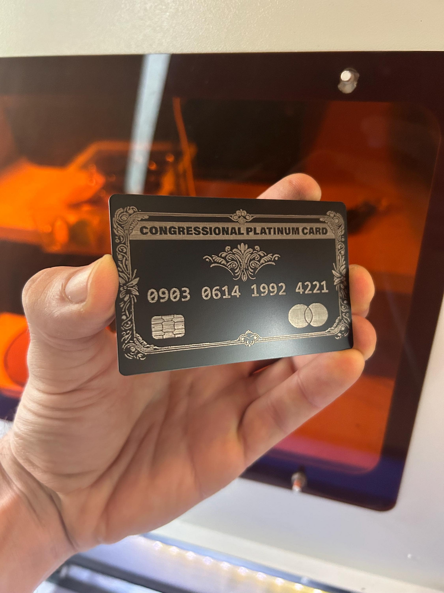 Hand holding a custom engraved gift card with Congressional Platinum Card text in front of a blurred background