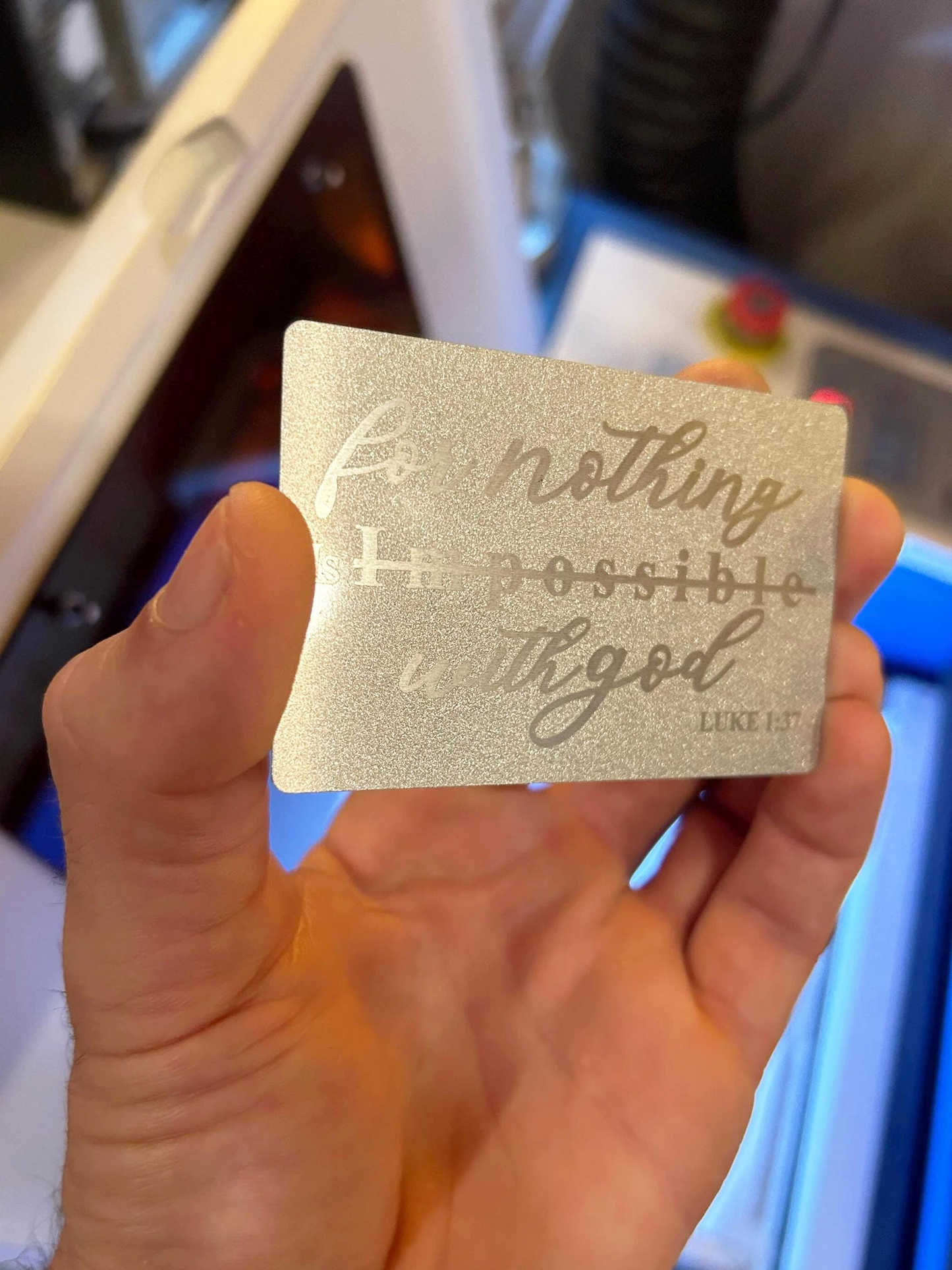 Hand holding a gold card with inspirational quote, blurred background