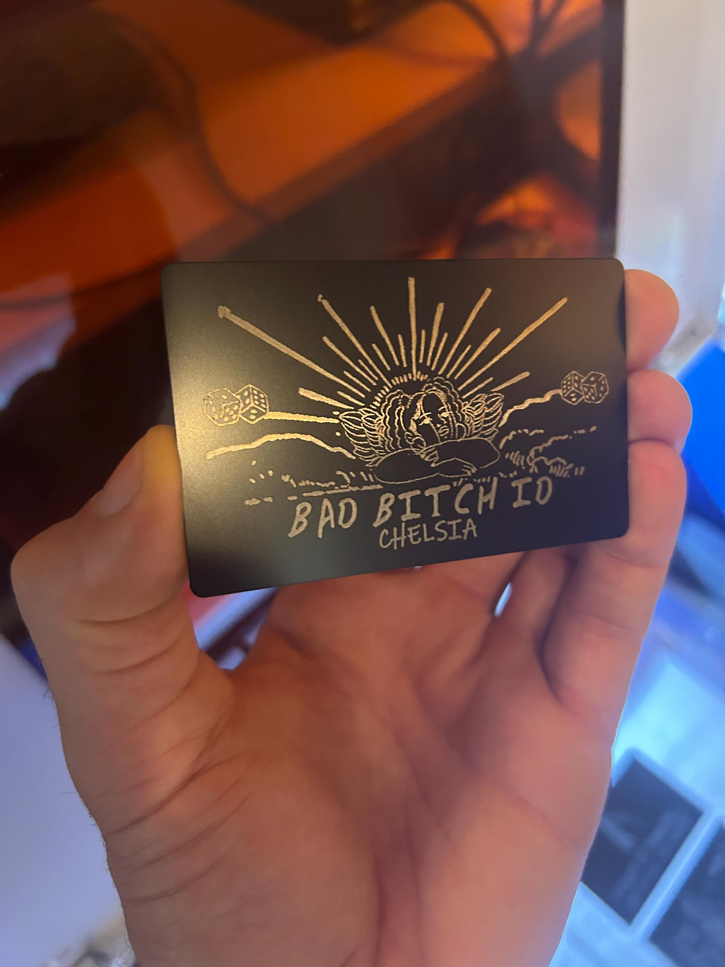 Hand holding a card with 'Bad Bitch ID' text and graphic design.