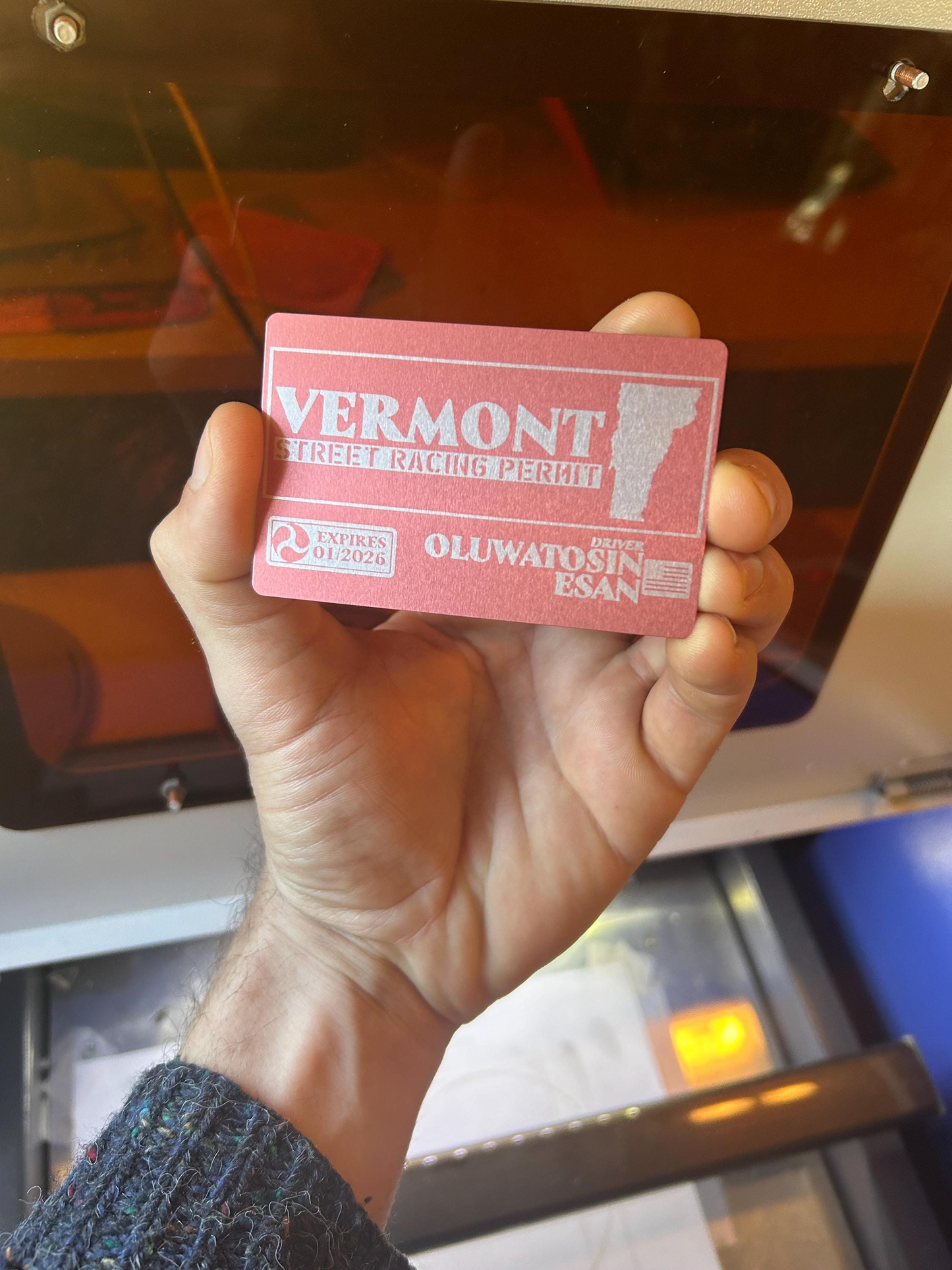 Hand holding a rose gold vermont themed street racing gag gift permit with custom laser engraved text