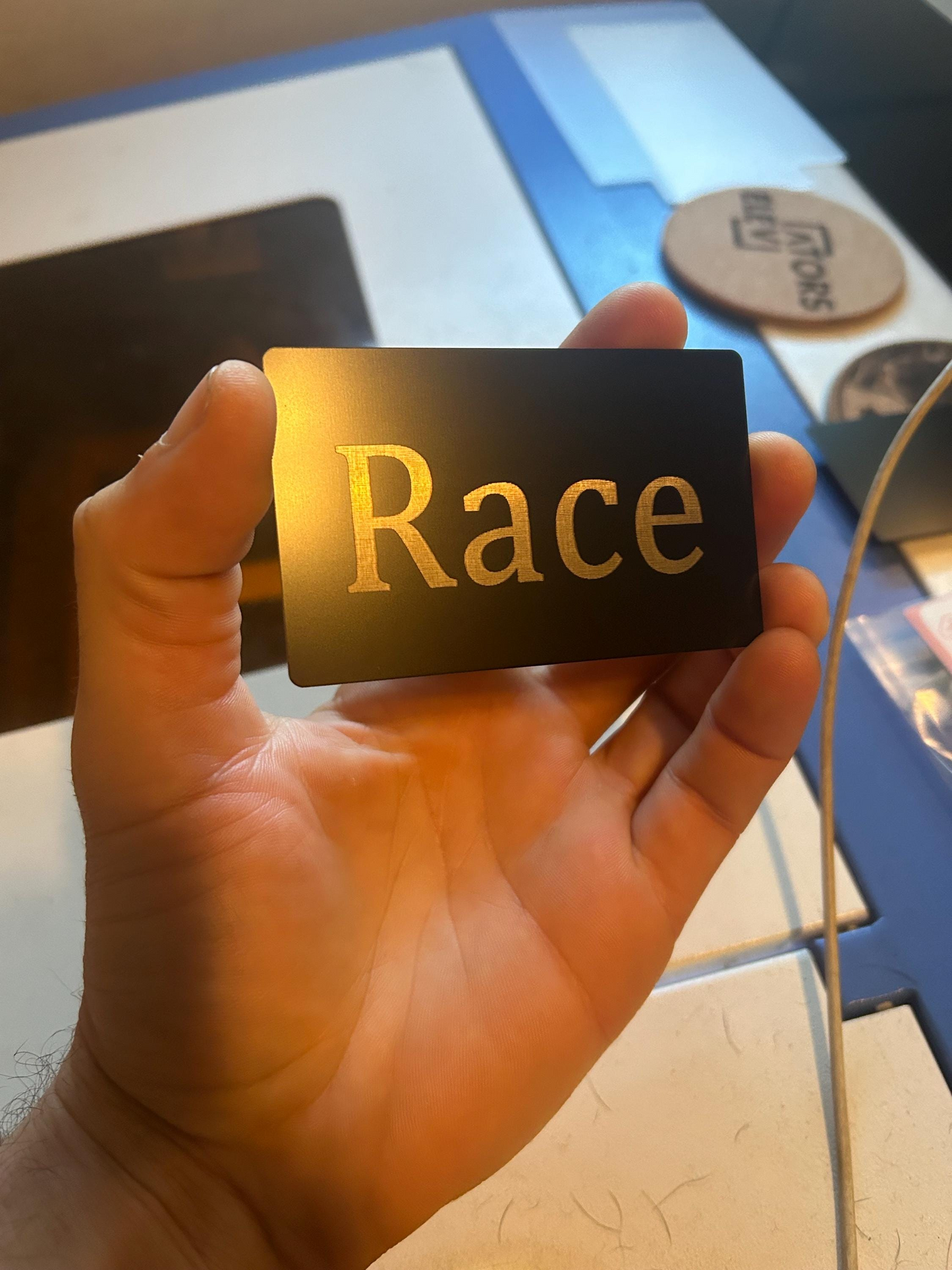 Hand holding Metal gag gift "Race Card" laser engraving saracastic gift