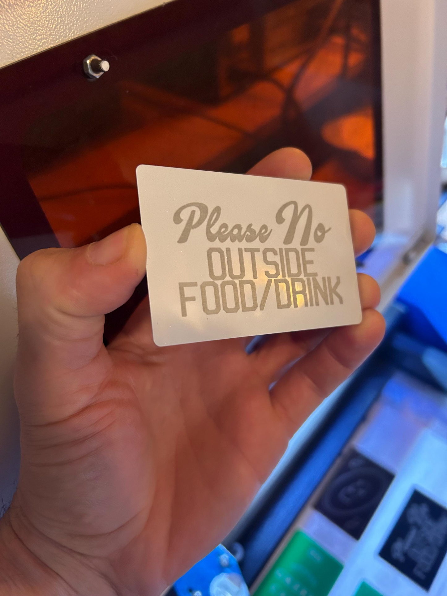 White and silver metal retail signage placard, with Please Outside Food/Drinks laser engraved text