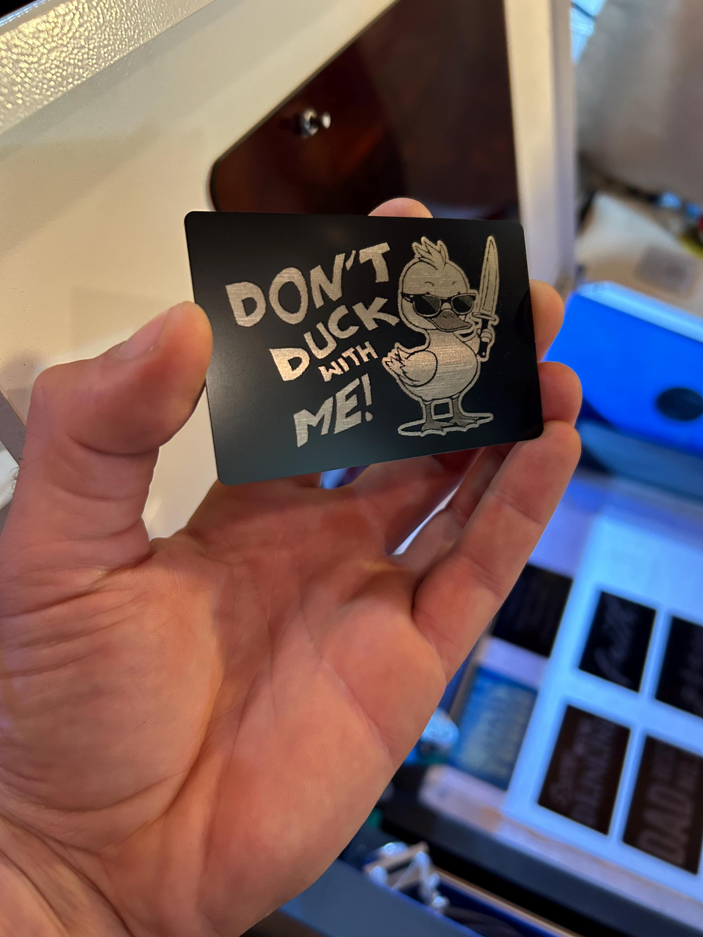 Person holding a funny engraved metal gift card with cute duckling artwork and “DON’T DUCK WITH ME” phrase