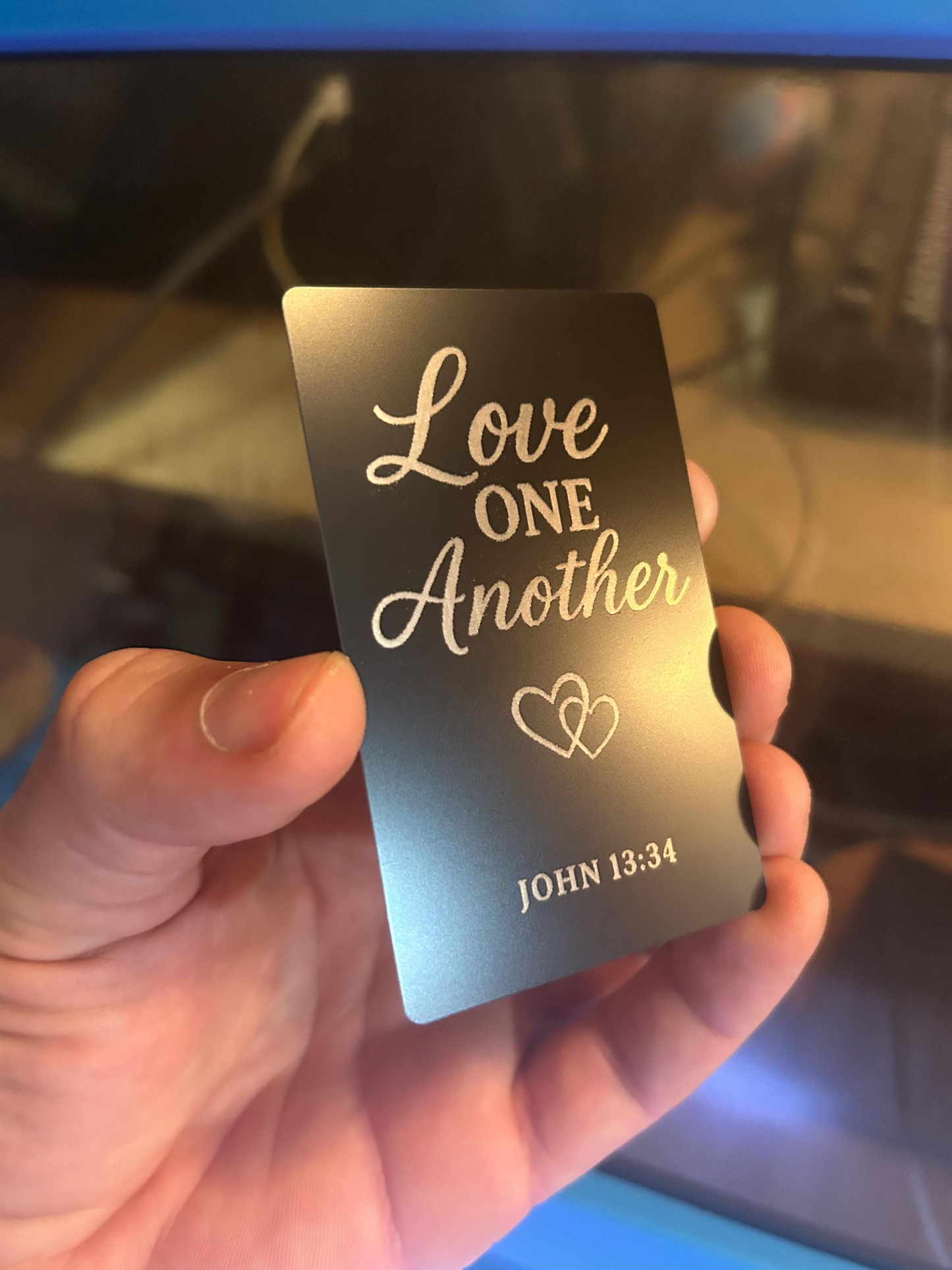 Detailed view of custom black metal Christian gift plaque engraved with “Love One Another” and John 13:34 scripture