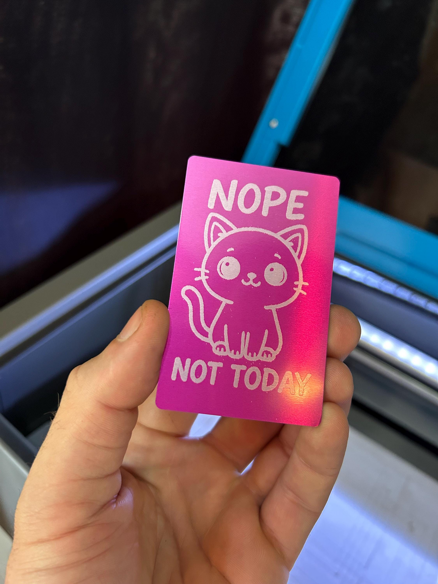 Pink card with a pet illustration and text held by a hand against a blurred background