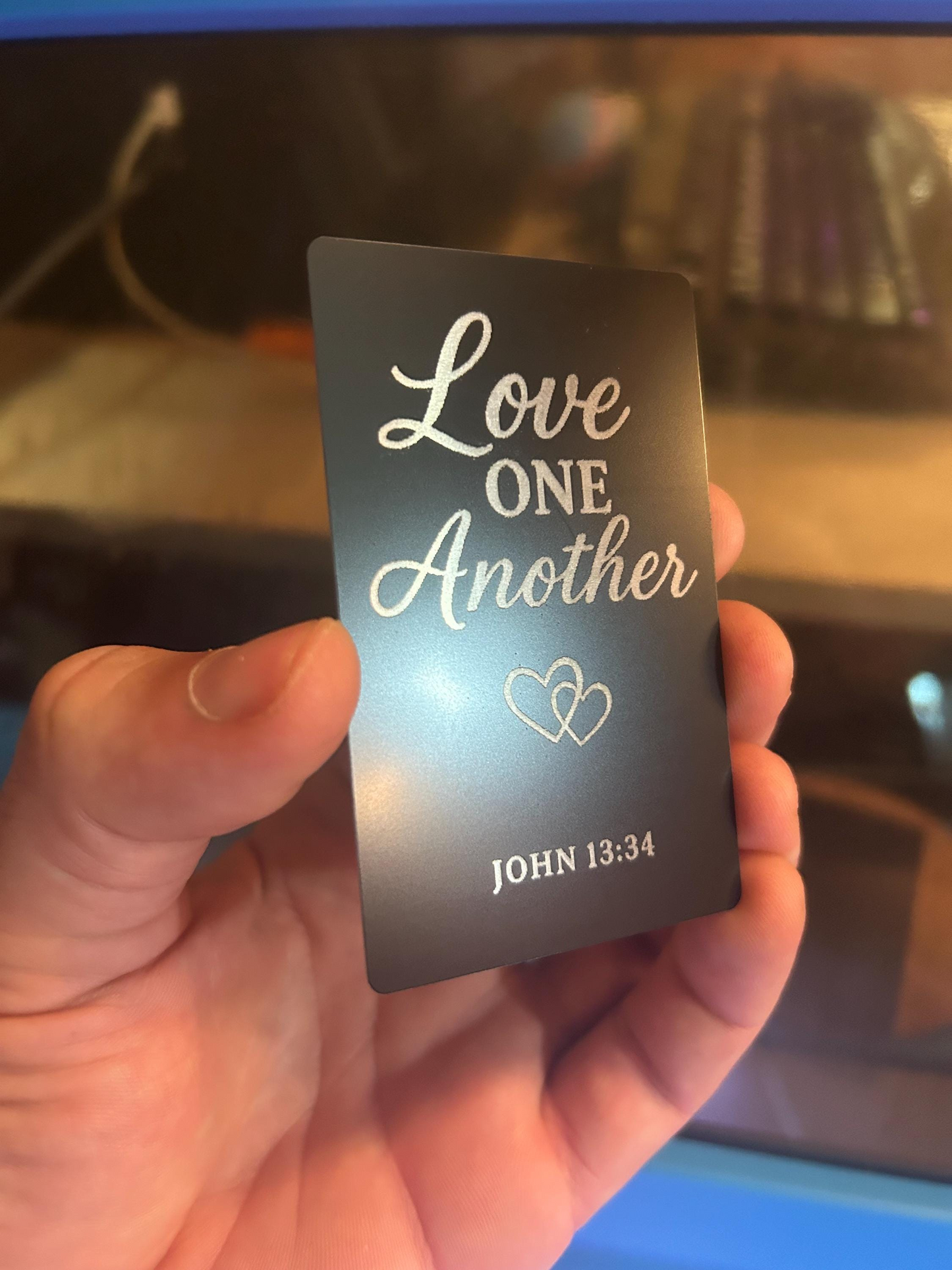 Inspirational engraved metal sign – “Love One Another” typography with Bible reference in silver on black