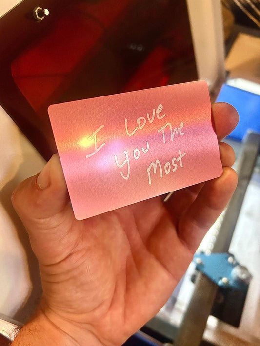 Metal laser engraved keepsake card that reads I Love You The Most in rose gold/silver anodized aluminum