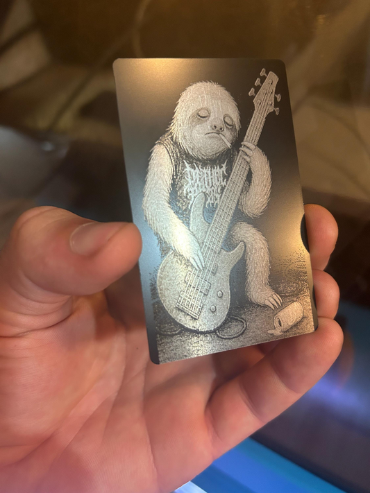 Laser engraved metal gift card with a cartoon sloth playing a guitar illustration
