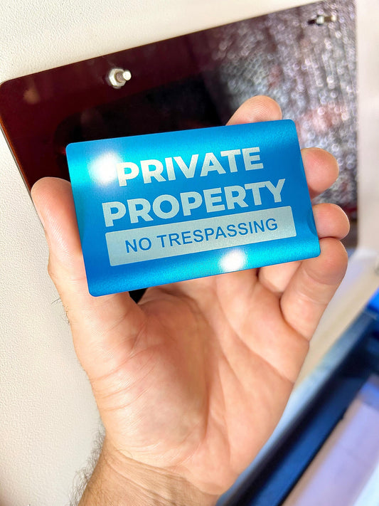 Private Property, No Trespassing" laser engraved sign in blue/silver