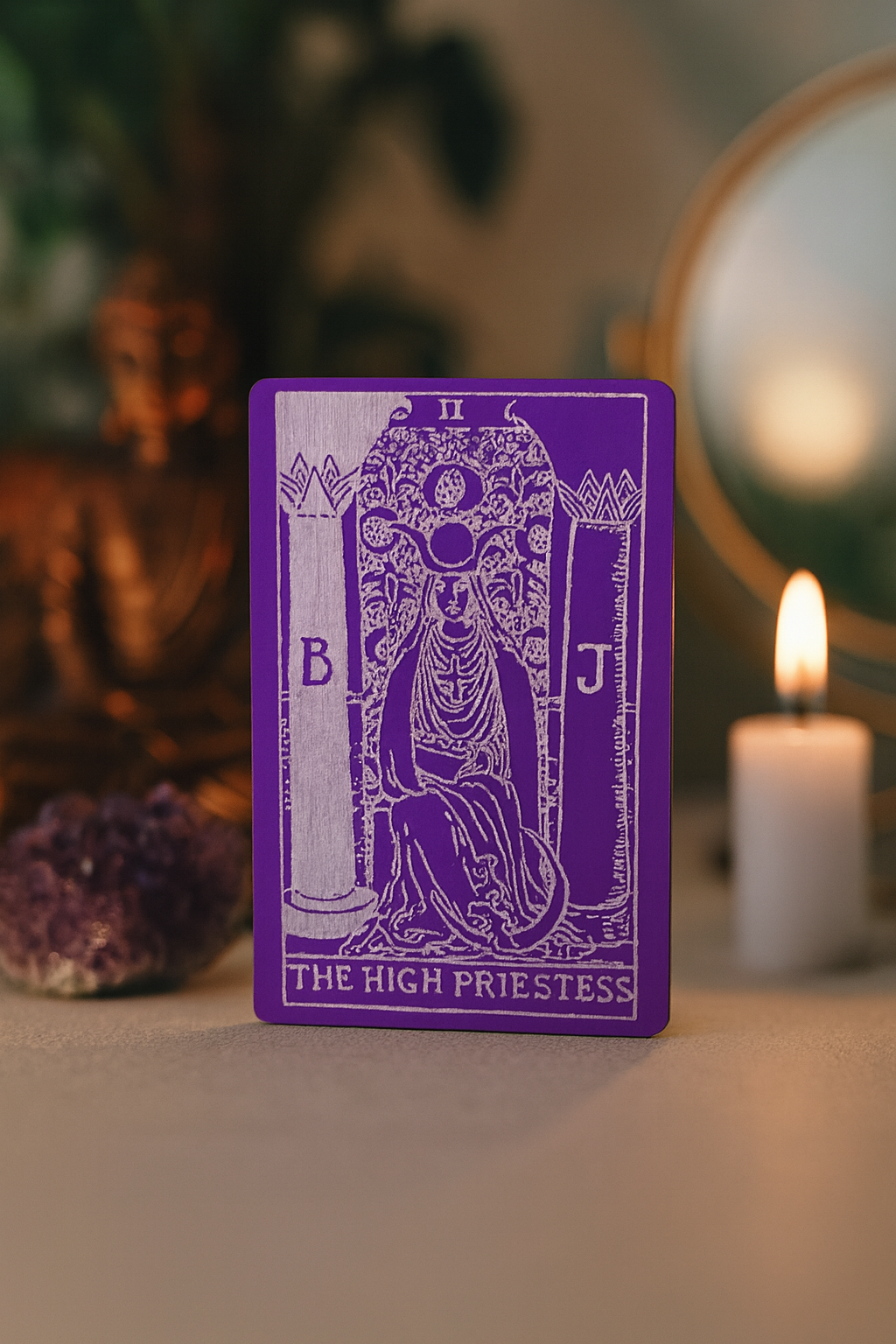 Purple/silver tarot card titled 'The High Priestess' laser engraved with a candle and crystal in the background