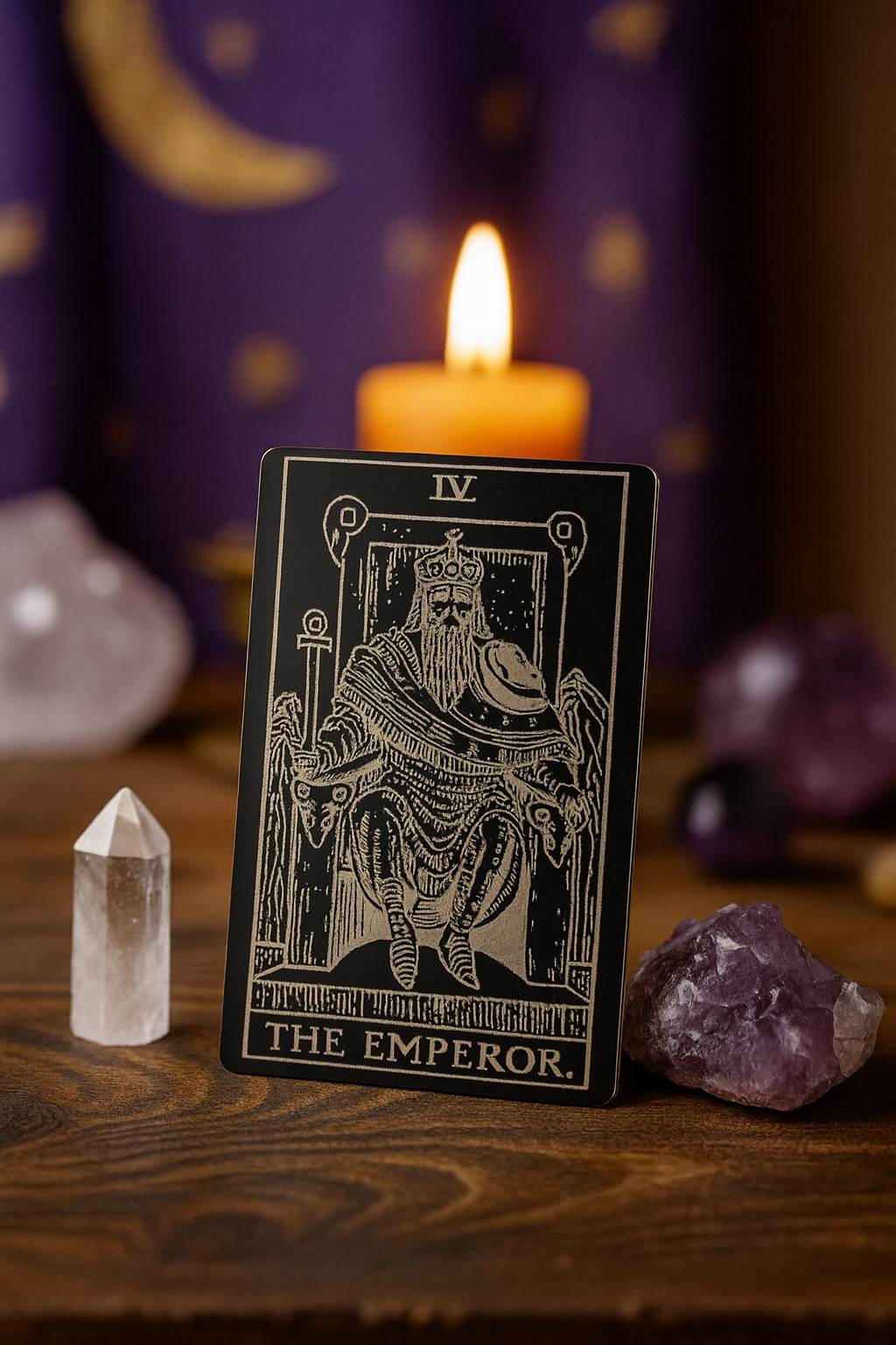 Anodized aluminum laser engraved Tarot card titled 'The Emperor' with a candle and crystals on a wooden surface