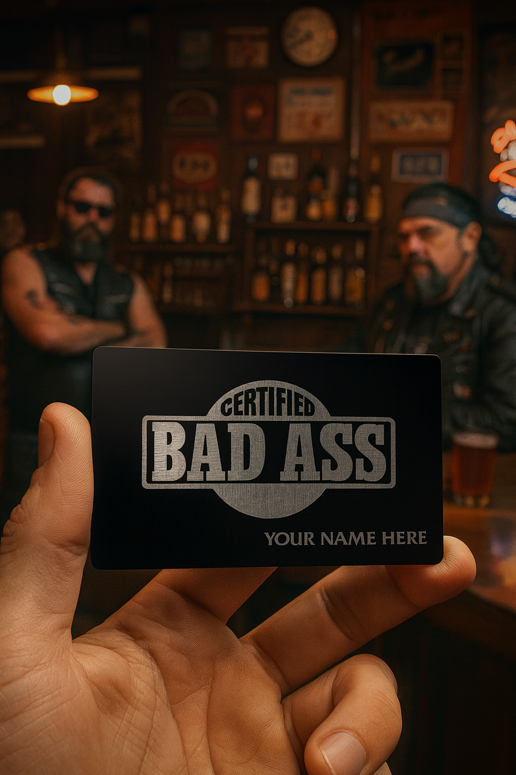 Hand holding a 'Certified Bad Ass' card with two people in the background in a bar setting.