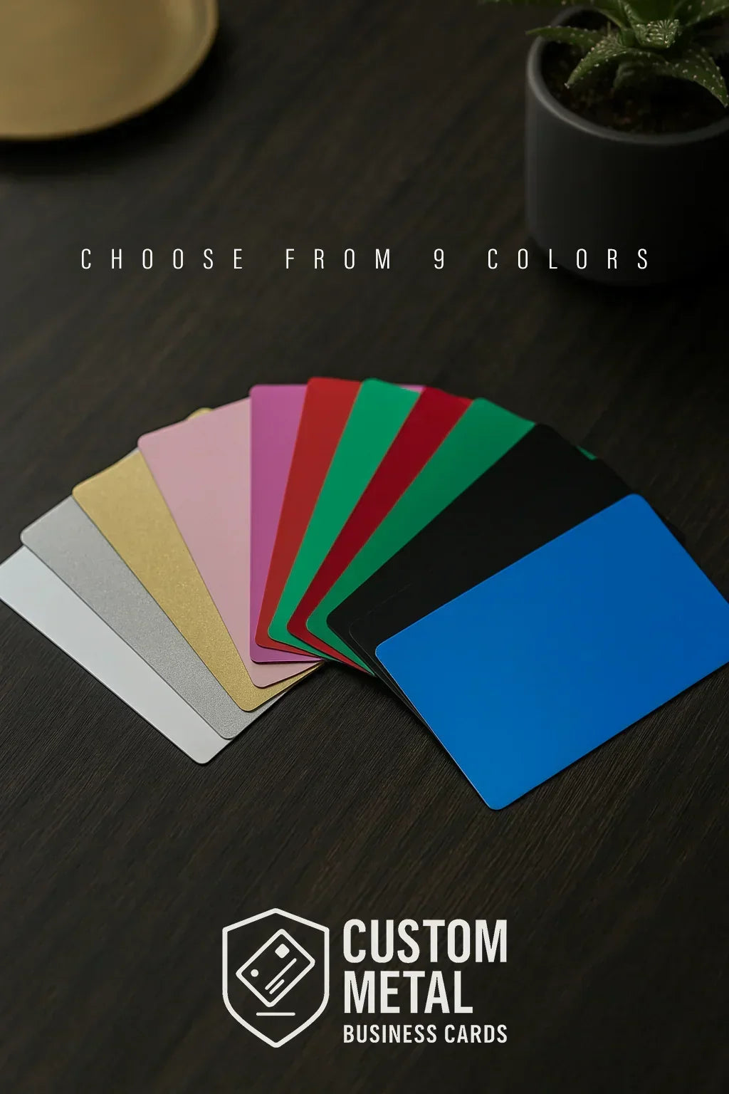 Set of custom metal business cards in 9 color options on a dark surface with 'Custom Metal Business Cards' branding.