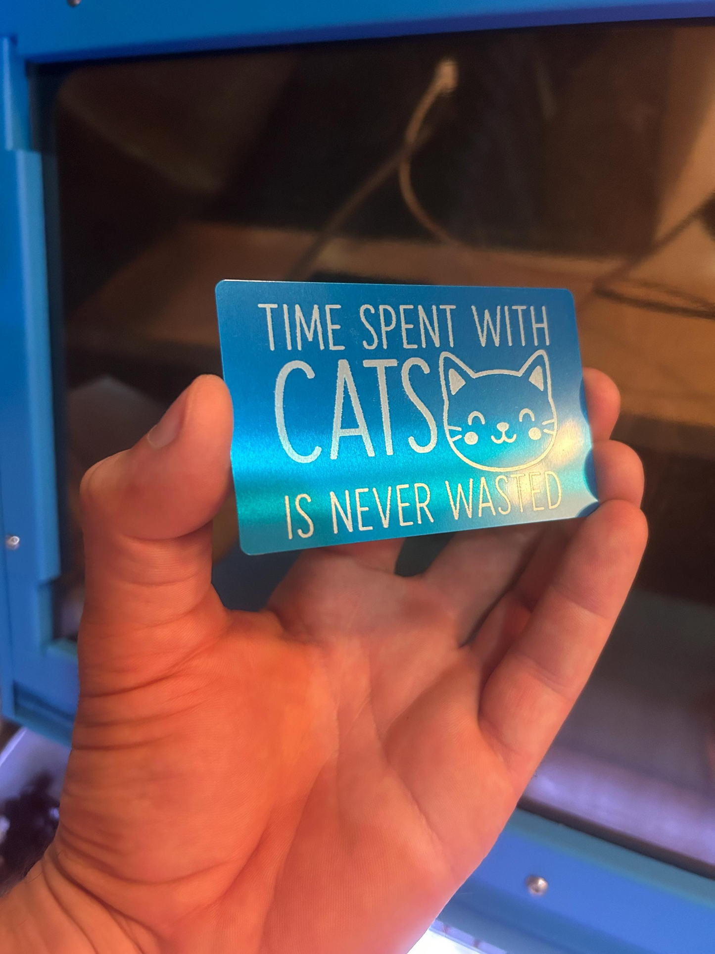 Person holding a laser engraved cat lover gift card with “Time Spent With Cats Is Never Wasted” typography and kitten image