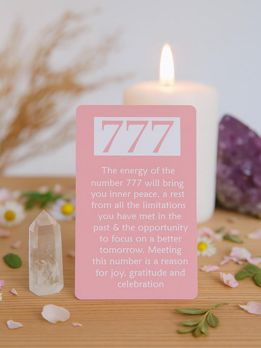 Card with '777' on a wooden surface with a candle and crystals