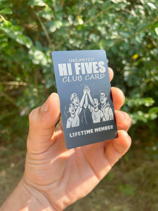 Hand holding a metal 'Unlimited Hi Fives Club Card' wallet insert with a green background
