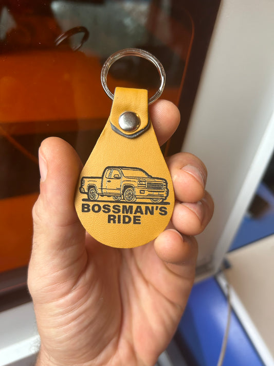 Hand holding a yellow leather key fob with custom text and logo laser engraving