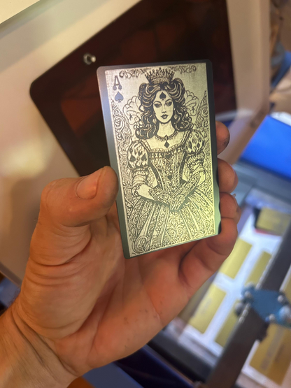 Hand holding a black and silver metal playing card with intricate Lady Luck Ace of Spades design – custom engraved keepsake