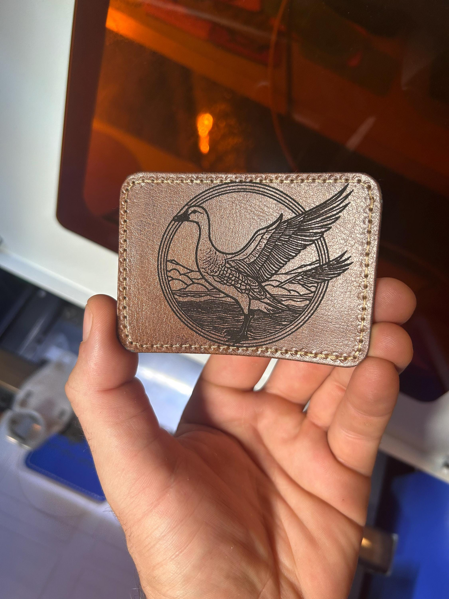 Dark brown leather patch with a goose design