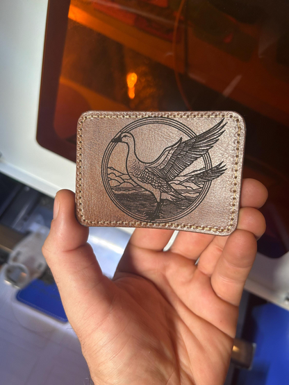 Dark brown leather patch with a goose design