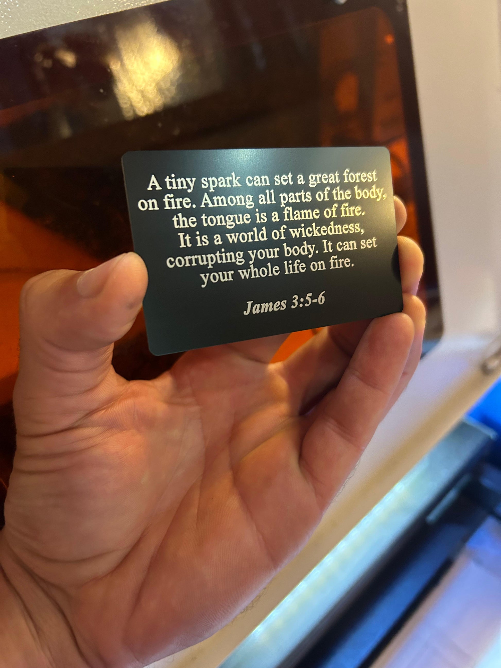Custom laser engraved metal bible verse card with James 3:5 text engraving in black/silver anodized aluminum