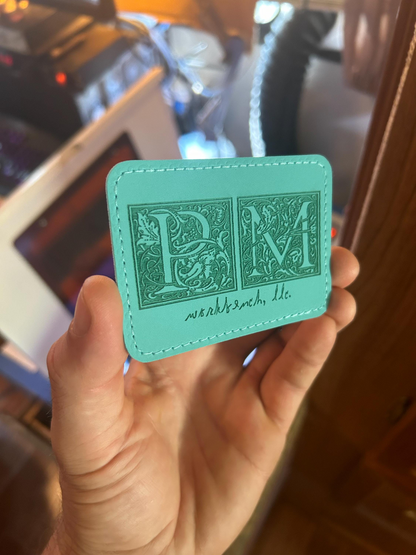 Teal laser engraved leather patch with detailed logo