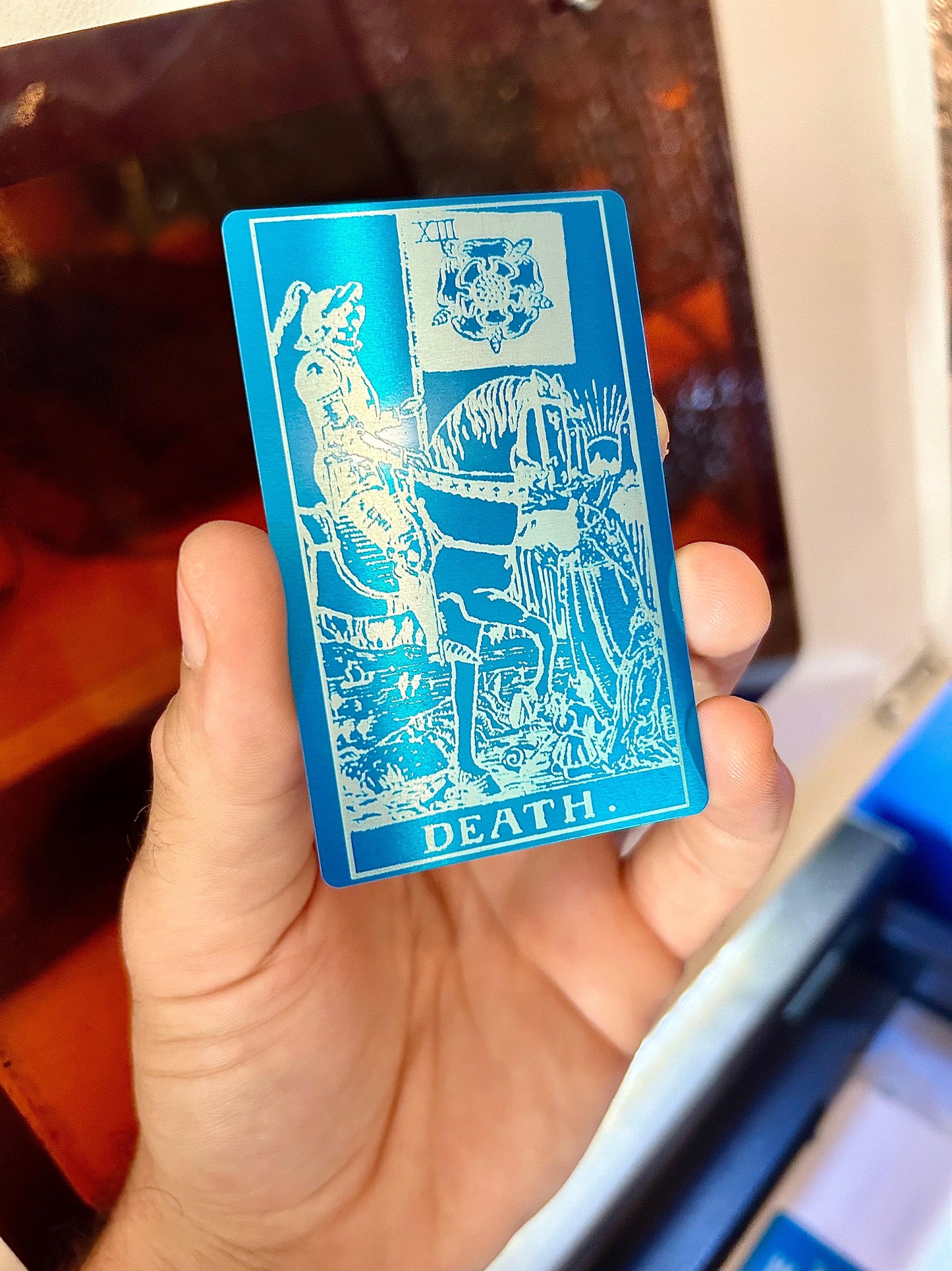 Metal tarot card in blue/silver anodized aluminum with "Death" design laser engraving