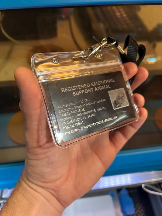 Hand holding a registered emotional support animal ID card in plastic sleeve lanyard badge holder
