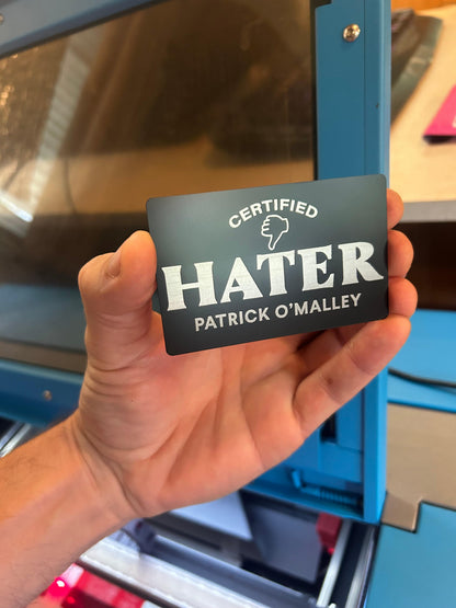 Laser engraved metal Certified Hater card with friend's name laser engraved below in black/silver