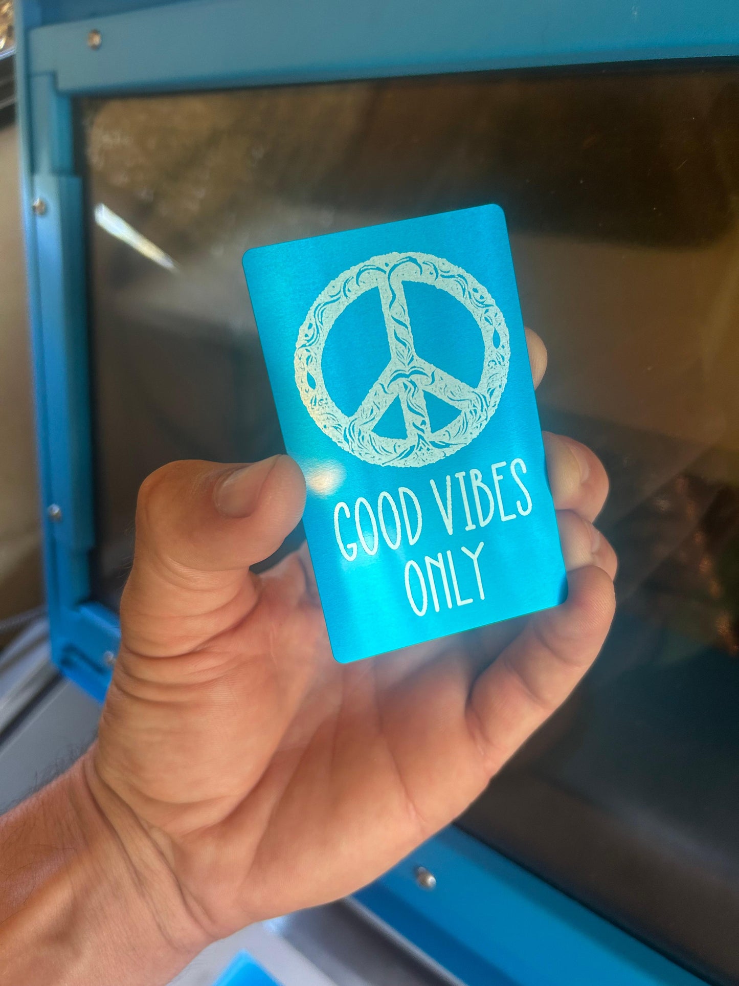 Laser engraved metal Good Vibes Only peace sign design in blue/silver