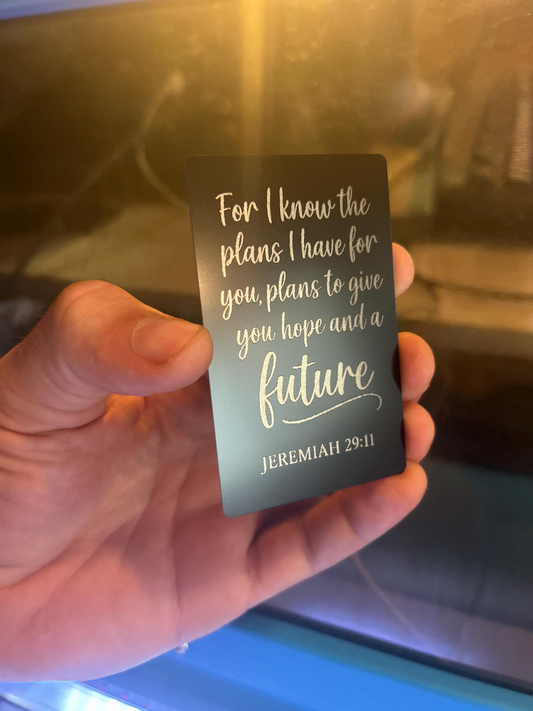 Hand holding a laser engraved faith inspired keepsake card with "For I Know the Plans I Have For You" quote from Jeremiah 29:11 against a blurred background