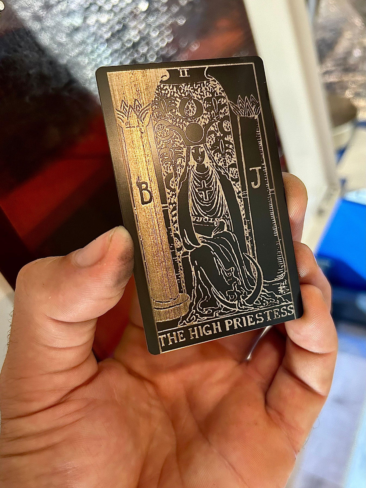 Laser engraved metal tarot card with The High Priestess artwork in black/silver anodized aluminum