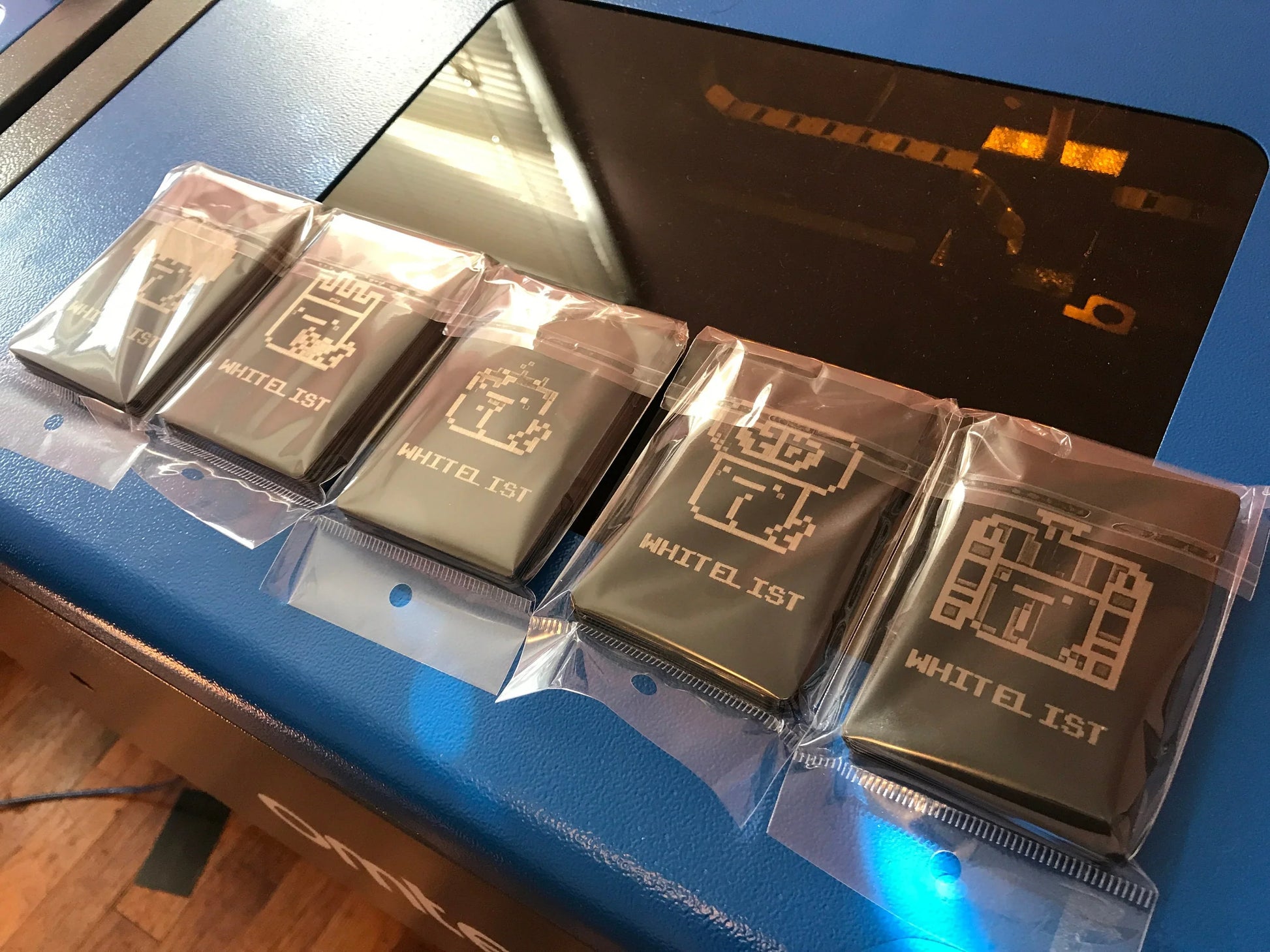 Four packages of 100 Metal Business Cards each, with custom engraved double-sided artwork and branding for video game company