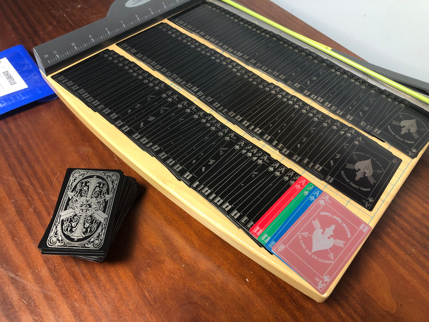 Collection of custom laser engraved set of playing cards with a deck on a wooden surface