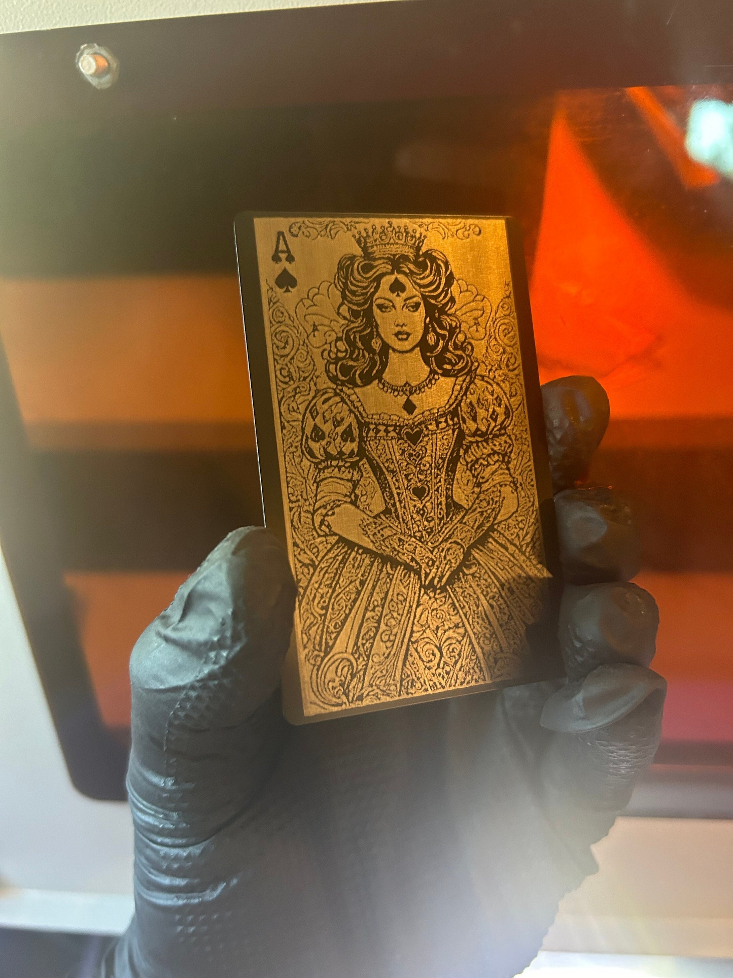 Hand presenting intricate Lady Luck Ace of Spades metal card in black and silver, blurred backdrop