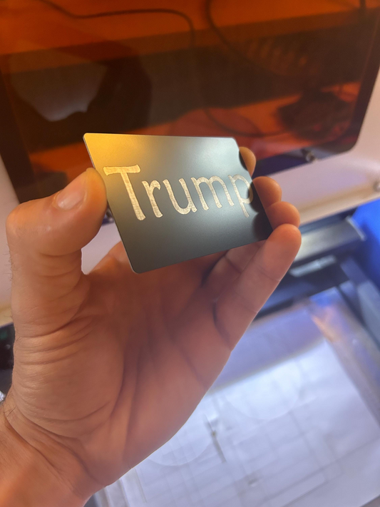Hand holding a metallic Trump Card gag gift