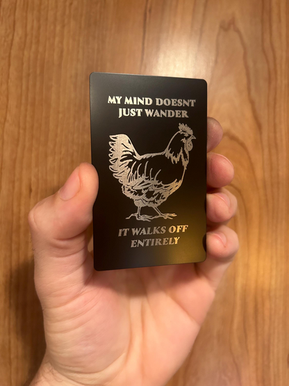 Detailed view of engraved anodized aluminum gag gift card with silly chicken design and inspirational humor quote