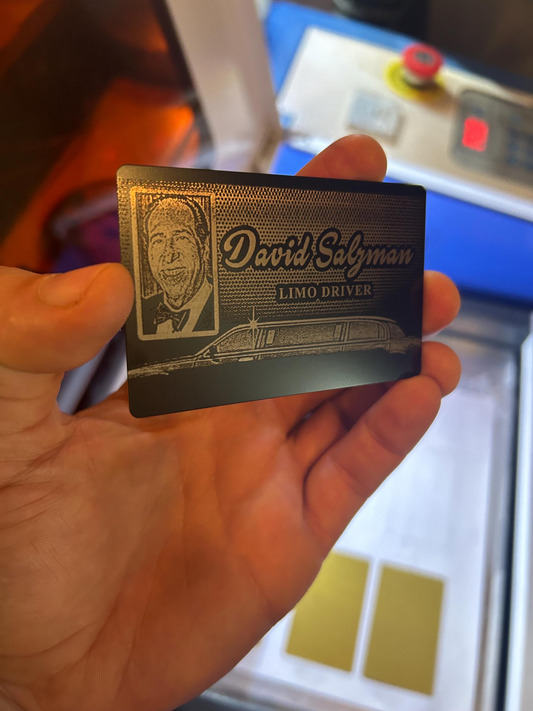 Hand holding a metal black/silver id badge card with laser engraved limo license text and a portrait, against a blurred background.