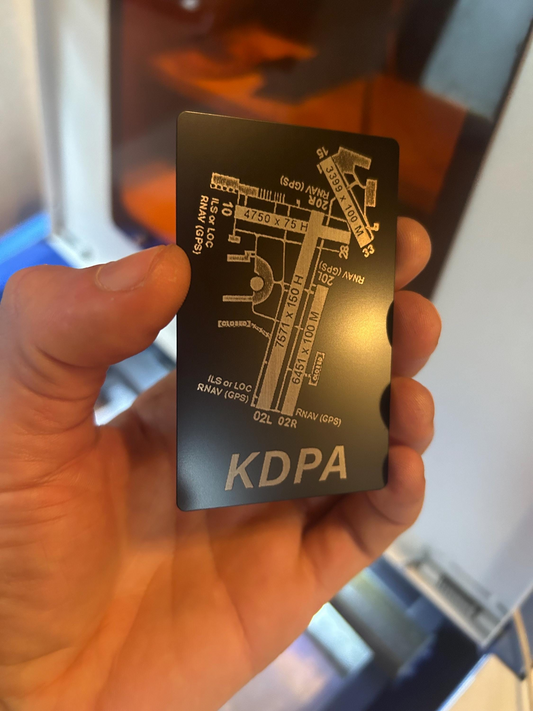 Hand holding a metallic engraved card with airport diagram 