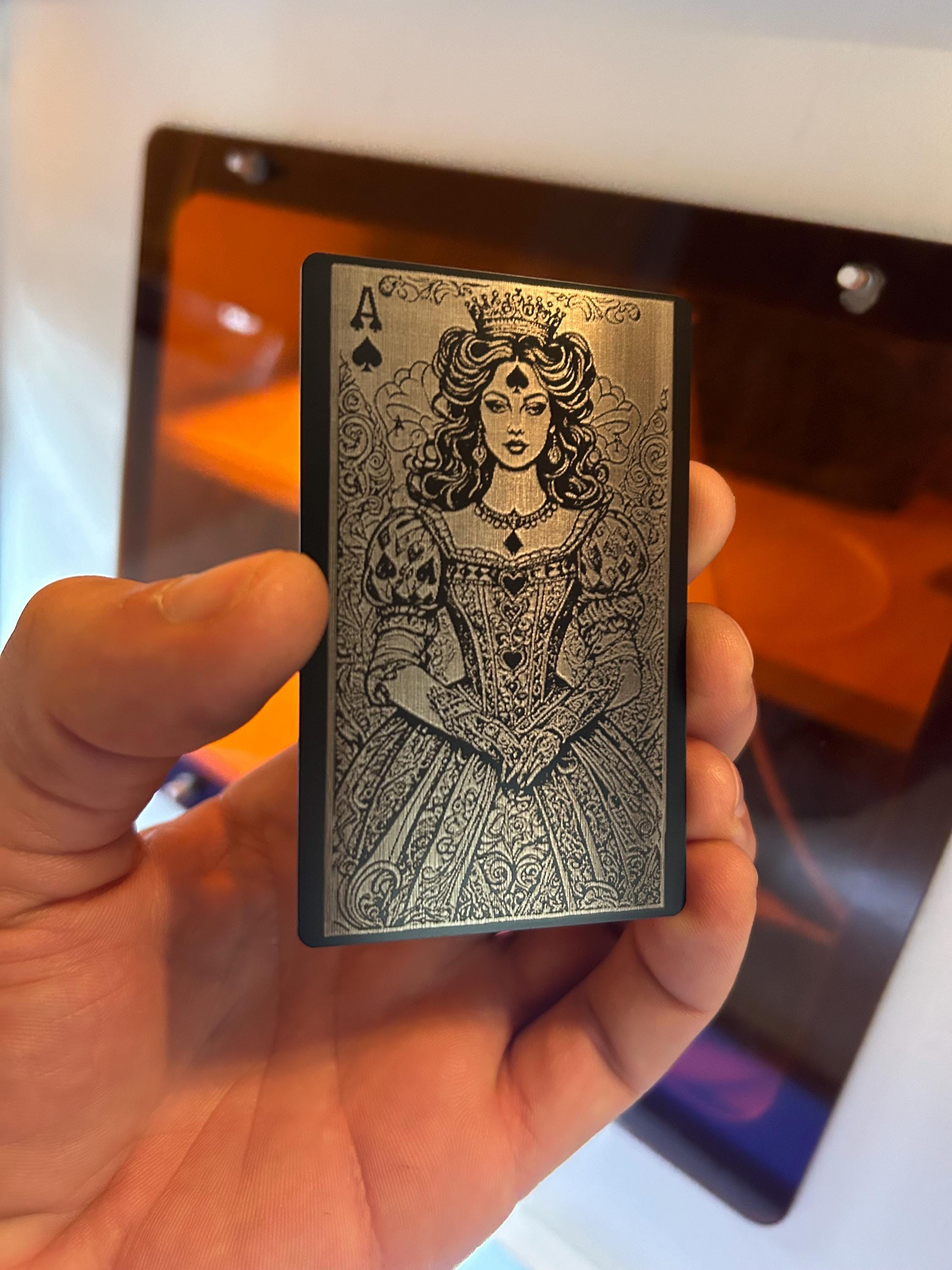 Angled shot of custom black and silver engraved playing card featuring Lady Luck Ace of Spades design in hand